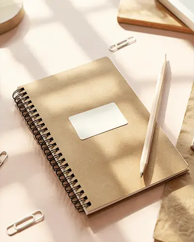 notebook-sticker-mockup-with-pencil-and-paperclips-on-pastel-desk