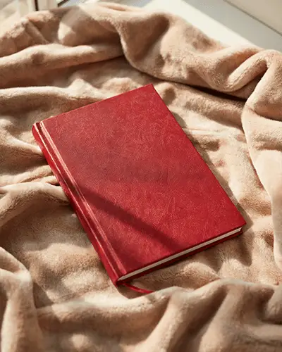 closed-leather-bound-notebook-sticker-mockup-with-ribbon-marker-on-velvet-texture