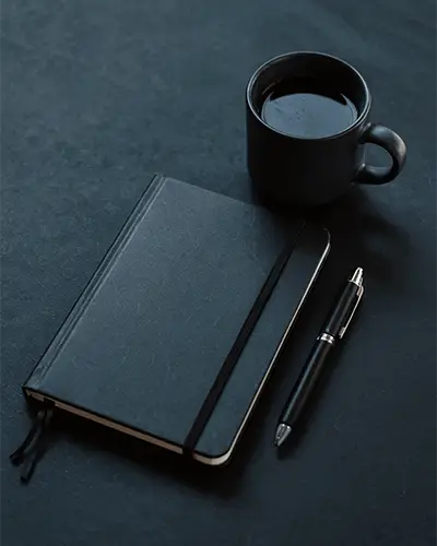 black-leather-notebook-sticker-mockup-with-pen-and-mug-on-minimalist-organized-workspace