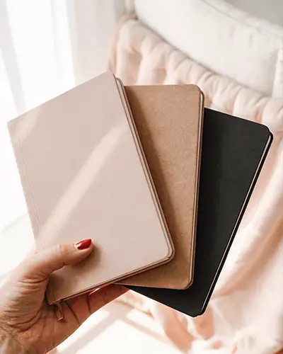 hand-holding-three-sleek-journals-sticker-mockup-with-rounded-corners-and-minimalist-design