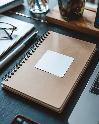 modern-office-desk-scene-with-laptop-and-notebook-sticker-mockup