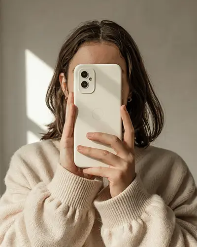minimal-phone-case-sticker-mockup-with-modern-sweater-and-natural-light-for-design-presentation