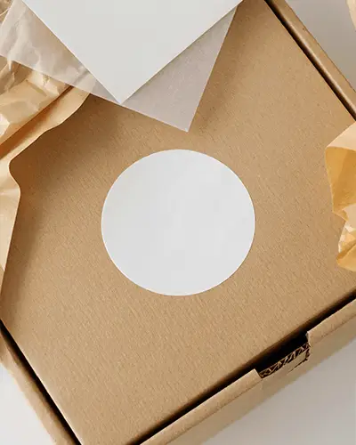 Blank Round Sticker Mockup Label On Environmentally Friendly Kraft Packaging