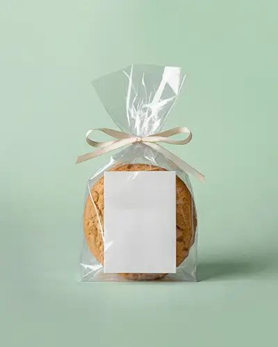 Clear Cookie Packaging Sticker Mockup With Blank Label And Beige Ribbon On Soft Pastel Background
