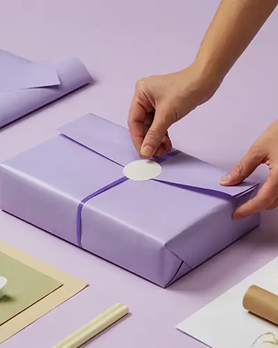 Premium Sticker Mockup On Elegant Purple Gift Wrap For Branding And Personalized Packaging