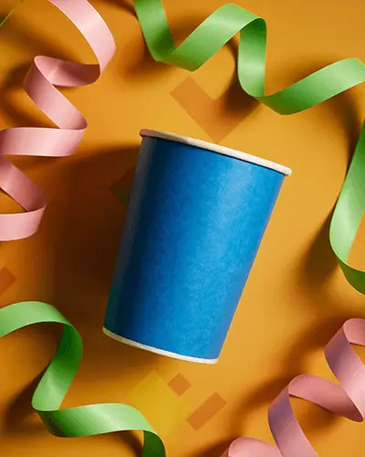 Blank Paper Cup Sticker Mockup Surrounded By Curled Streamers For Party Decors
