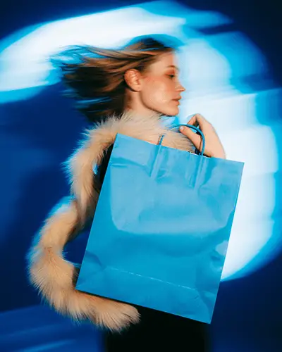 Sticker Mockups Fashion Model In Motion Holding Blue Shopping Bag With Dynamic Light Trails