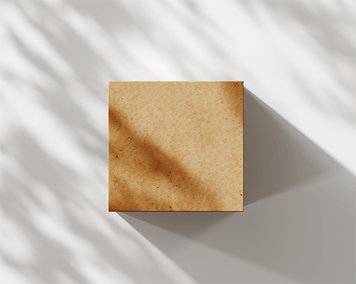 Square Brown Box Sticker Mockup On Table With Shadow Play Natural Lighting And Minimalistic Design