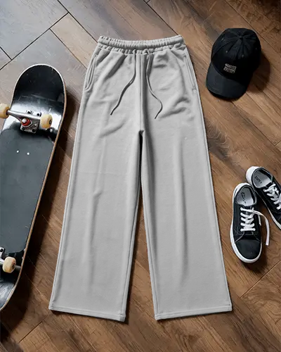 flatlay-wide-leg-sweatpant-mockup-on-wooden-floor-with-skateboard-cap-and-casual-sneakers