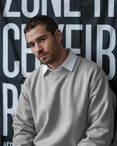 Urban Backdrop Sweatshirt Mockup Male Model In Light Grey Crewneck With White Collar Shirt Serious Expression Modern Street Style