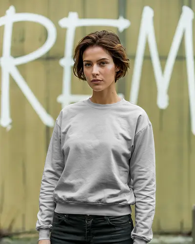 Gritty Urban Sweatshirt Mockup Female Model In Grey Crewneck Standing Against Painted Wall Bold Expression Edgy City Vibe