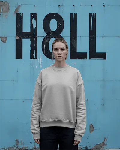 Grunge Wall Sweatshirt Mockup Female Model Standing Against Weathered Blue Background Edgy Urban Style Moody Expression Raw Texture