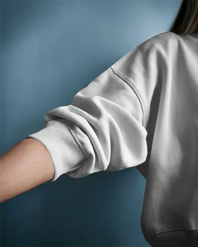 Stylish Detail Sweatshirt Mockup Female Model Arm And Shoulder Closeup Blue Background Multiple Print Views Folded Sleeve Modern Editorial Look
