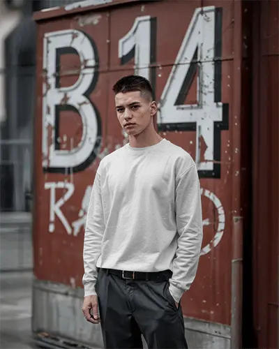 Gritty Street Sweatshirt Mockup Male Model Standing In Front Of Weathered Red Container Bold Urban Background Cool Toned Styling Edgy Vibe
