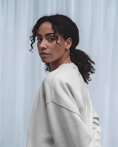 Side View White Sweatshirt Mockup On Female Model Against Soft Light Curtain 