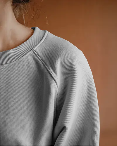 close-up-white-sweatshirt-mockup-on-female-model-against-warm-earthy-background