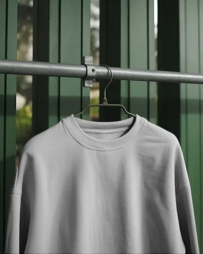 sweatshirt-mockup-hanging-on-metal-rod-against-green-wooden-wall-outdoor-light