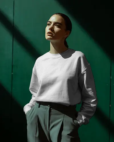 Dramatic Light Sweatshirt Mockup Female Model Standing In Sunlit Studio Against Dark Green Wall