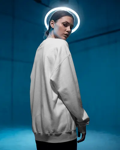 Moody Editorial Sweatshirt Mockup Woman In Side Pose Under Glowing Halo Against Studio Wall