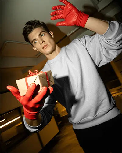 Modern Christmas Sweatshirt Mockup Male Model With Red Gloves Holding Gift In Studio Light