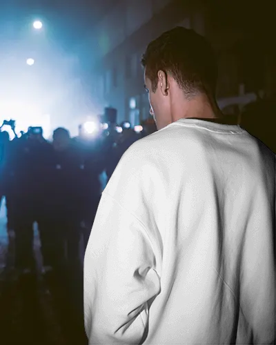 Sweatshirt Mockup Back View Male Model In Nighttime Street Scene With Crowd And Cinematic Lights