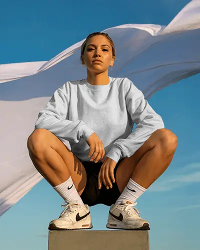 Outdoor Sweatshirt Mockup Female Model Squatting On Pedestal Blue Sky Background