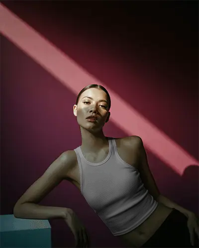 Cinematic Fashion Tank Top Mockup Female Model Under Spotlight With Deep Shadow And Purple Wall 063