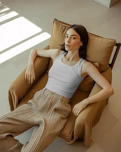 relaxed-sunlit-tank-top-mockup-female-model-lying-on-tan-chair-in-modern-interior-with-soft-shadows-072