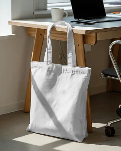 Tote Bag Mockup Hanging Desk Natural Light Home Office Setting Cozy Environment Casual Style