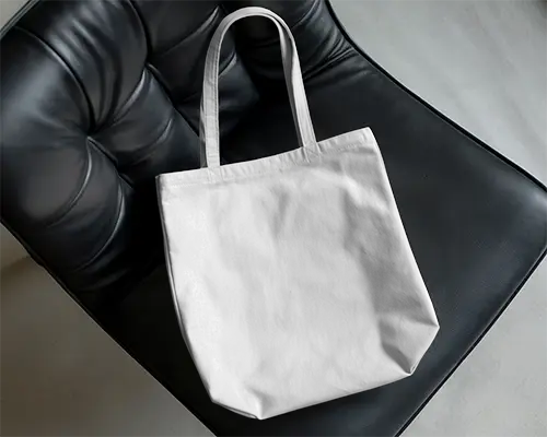 Modern Interior Tote Bag Mockup On Black Leather Chair With Natural Light And Soft Shadow 0291