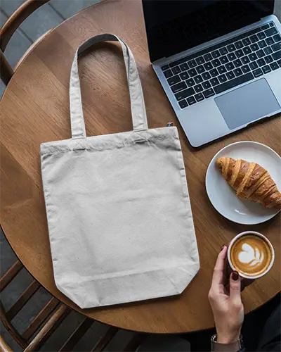 Cafe Scene Tote Bag Mockup On Wooden Table With Laptop Croissant And Latte In Modern Coffee Shop 0293