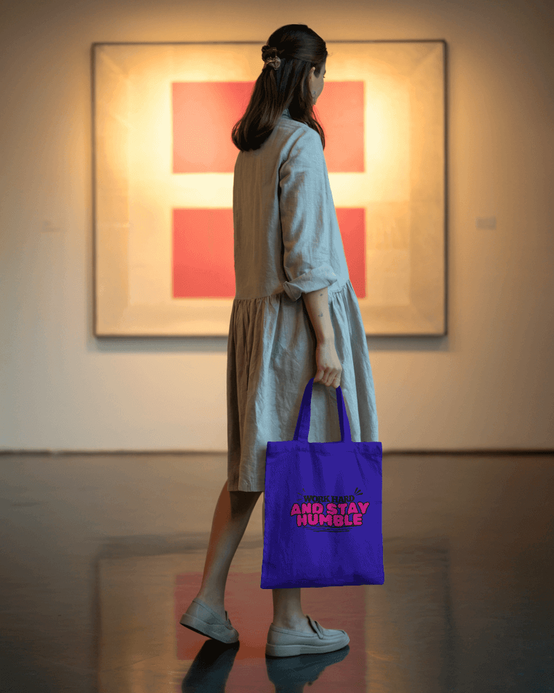 Woman Holding Minimalist Blank Tote Bag Mockup In Modern Art Gallery Setting