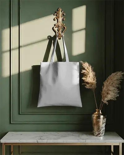 stylish-canvas-tote-bag-hanging-against-textured-wall-above-marble-top-table