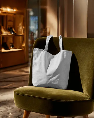 minimalistic-tote-bag-mockup-on-vintage-chair-in-high-end-store-environment