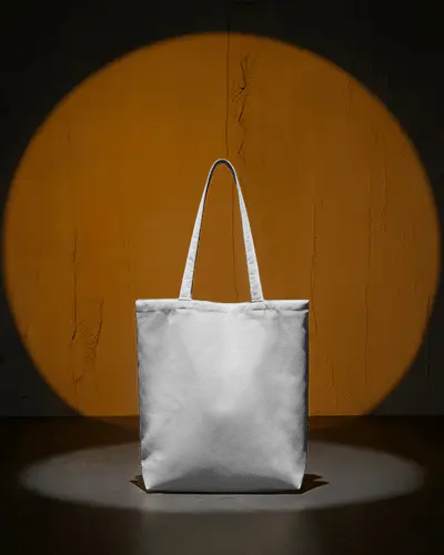 spotlight-tote-bag-mockup-against-textured-orange-wall-in-dark-studio