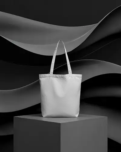 tote-bag-mockup-on-grey-podium-with-abstract-dark-wavy-backdrop-minimal-studio-style