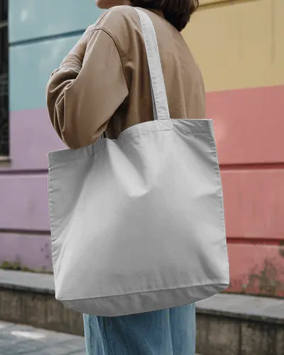 urban-tote-bag-mockup-on-shoulder-of-female-model-in-casual-outfit-near-colorful-wall-street