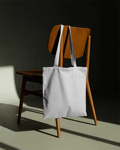 modern-minimal-tote-bag-mockup-hanging-on-wooden-chair-with-dramatic-lighting-stylish-display