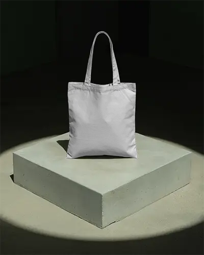 spotlight-tote-bag-mockup-on-concrete-platform-dramatic-dark-background-modern-branding-scene