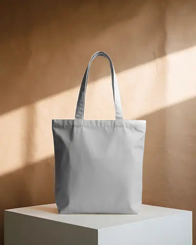 neutral-tote-bag-mockup-on-minimal-white-pedestal-with-soft-warm-light-against-brown-wall