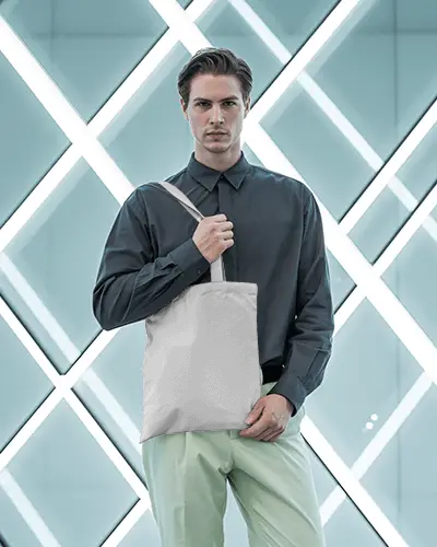 Modern Studio Tote Bag Mockup Man Standing Against Geometric Light Display