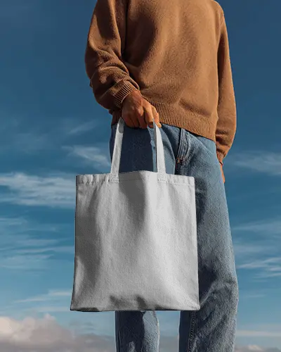 Handheld Outdoor Totebag Mockup With Casual Model Under Clear Blue Sky