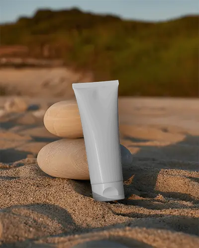slanted-cream-tube-mockup-positioned-outdoors-on-beach-sand-with-rocks-in-background