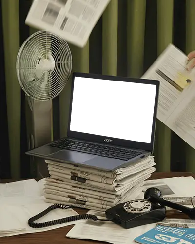 acer-laptop-mockup-on-stack-of-newspapers-with-rotary-phone-and-papers-flying-in-room