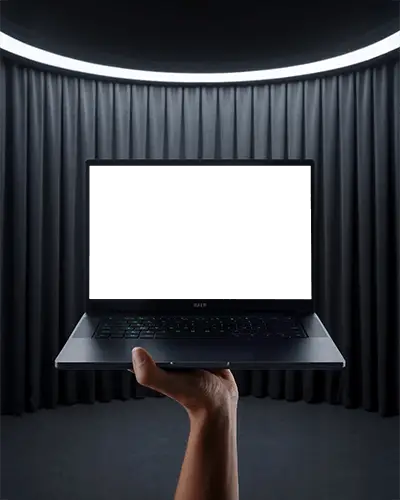 Razer Laptop Mockup Held By Hand In Modern Stage Setting With Dark Curtains And Light Ring