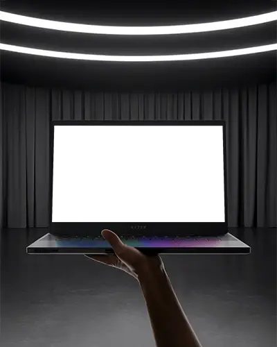 Razer Gaming Laptop Mockup Held In Hand Under Spotlight With Dark Curtains And Modern Stage
