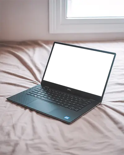 Dell Laptop Mockup On Bed In Cozy Bedroom With Soft Light From Window And Minimal Home Setting