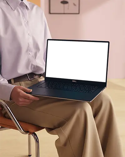 Dell Laptop Mockup Held On Lap By Person In Modern Office Setting With Soft Pastel Background