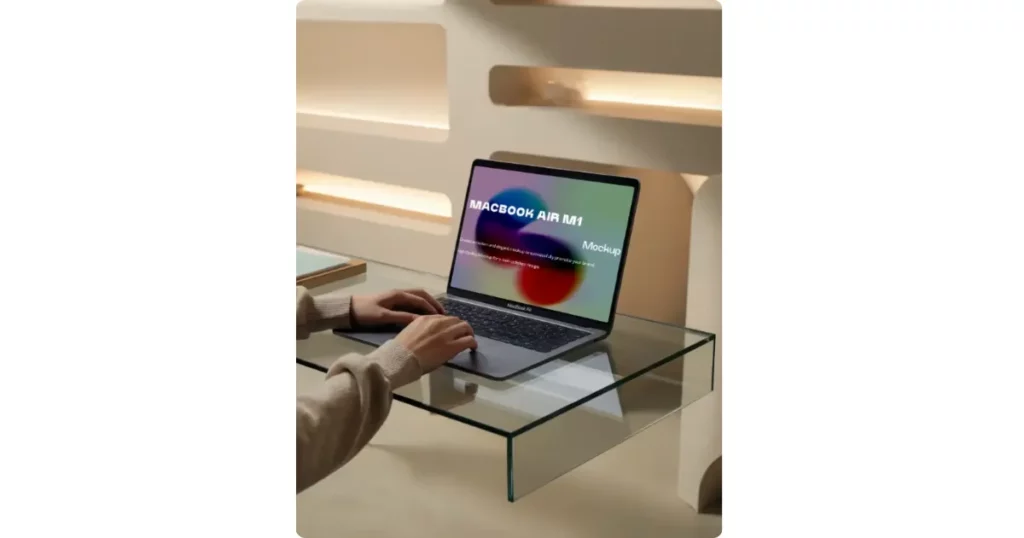 hand typing on a glass desk using a macbook air m1
