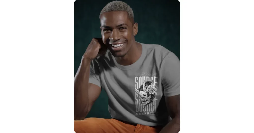 the man wears a t-shirt with elbows on knees